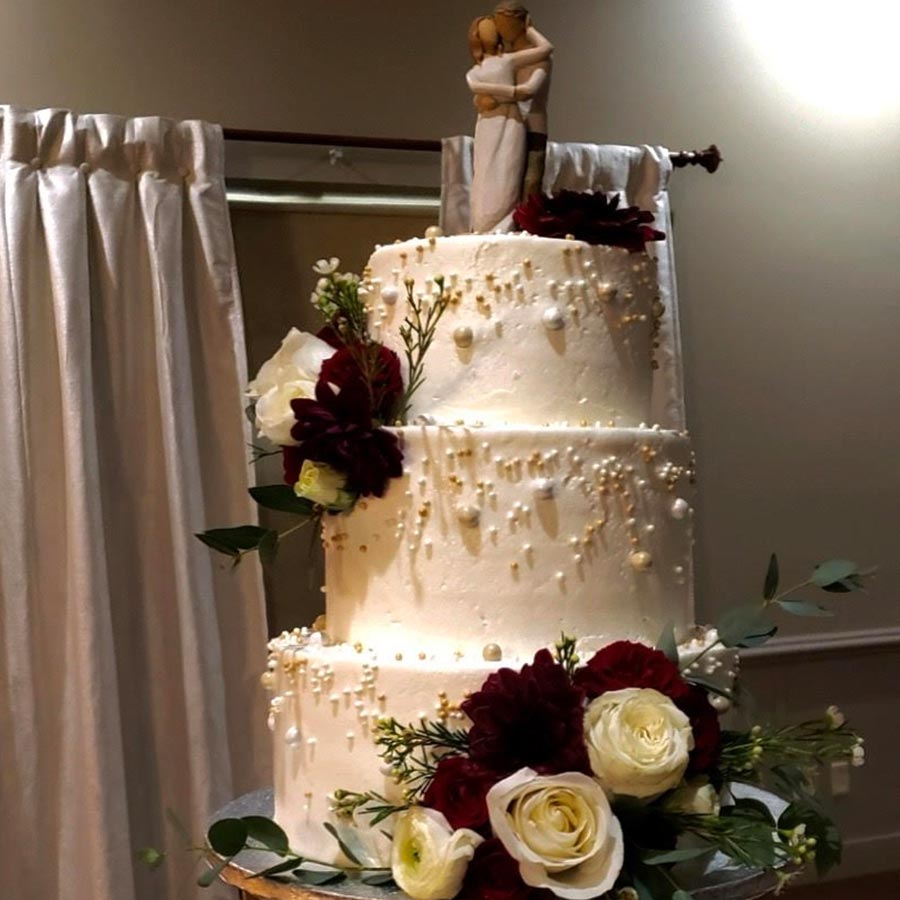 Three-tiered white wedding cake with flowers—contact Rochester Event Center to order yours.