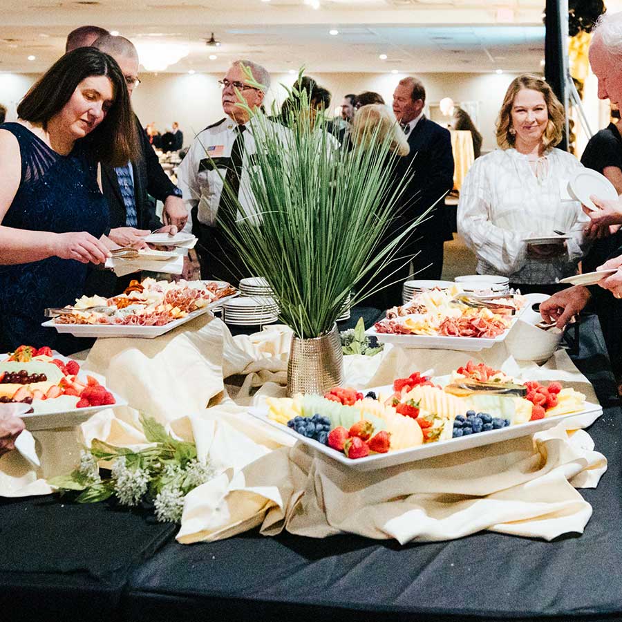 Guests serve themselves from fruit and cheese platters at the Rochester Event Center buffet table.